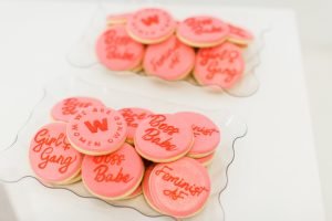 Pink & red custom We Are Women Owned Logo Cookies with some reading 