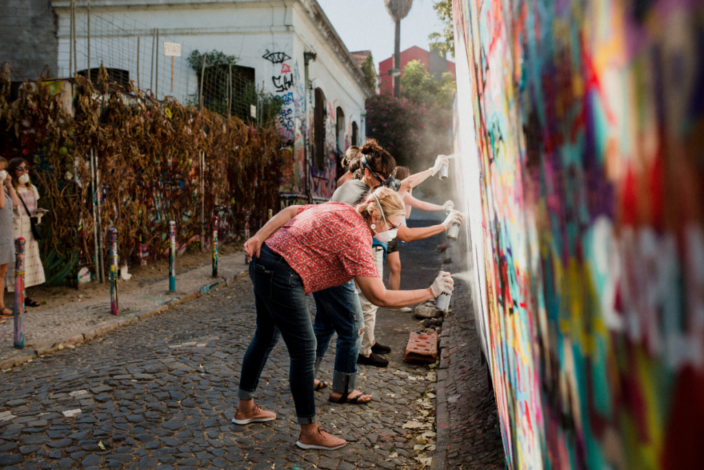 Women learning how to graffiti a wall in Portugal 