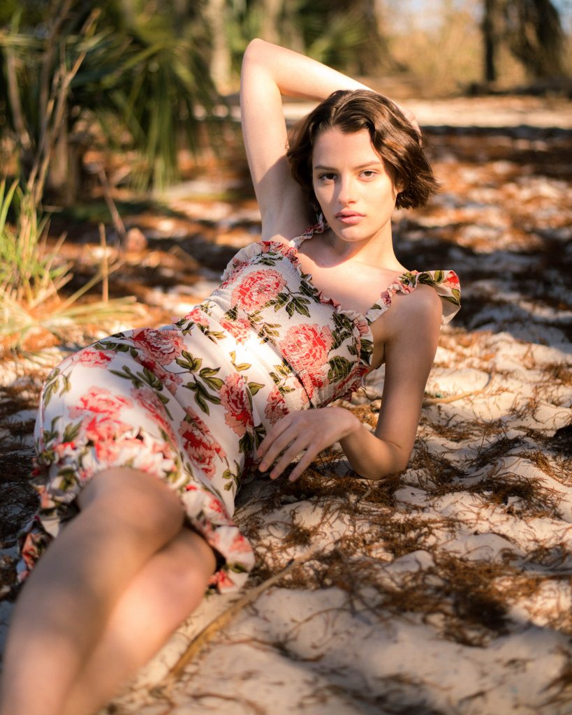 Woman in floral short dress by Noyette laying on ground