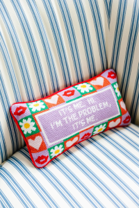 Purple, red, and green hand embroidered pillow with Taylor Swift lyrics that read It's Me. Hi. I'm the problem, it's me.